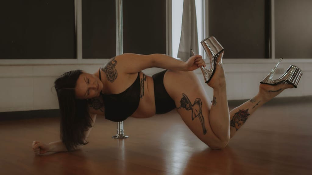Person posing on a pole in a studio setting